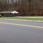 A community service member cleans along the side of a road in New Straitsville.