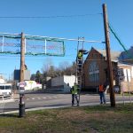 Two community service volunteers remove old Christmas lights and signs around New Straitsville.